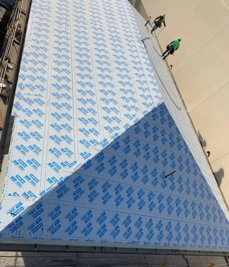 Professional roofers installing underlayment on a metal roof in West Lafayette